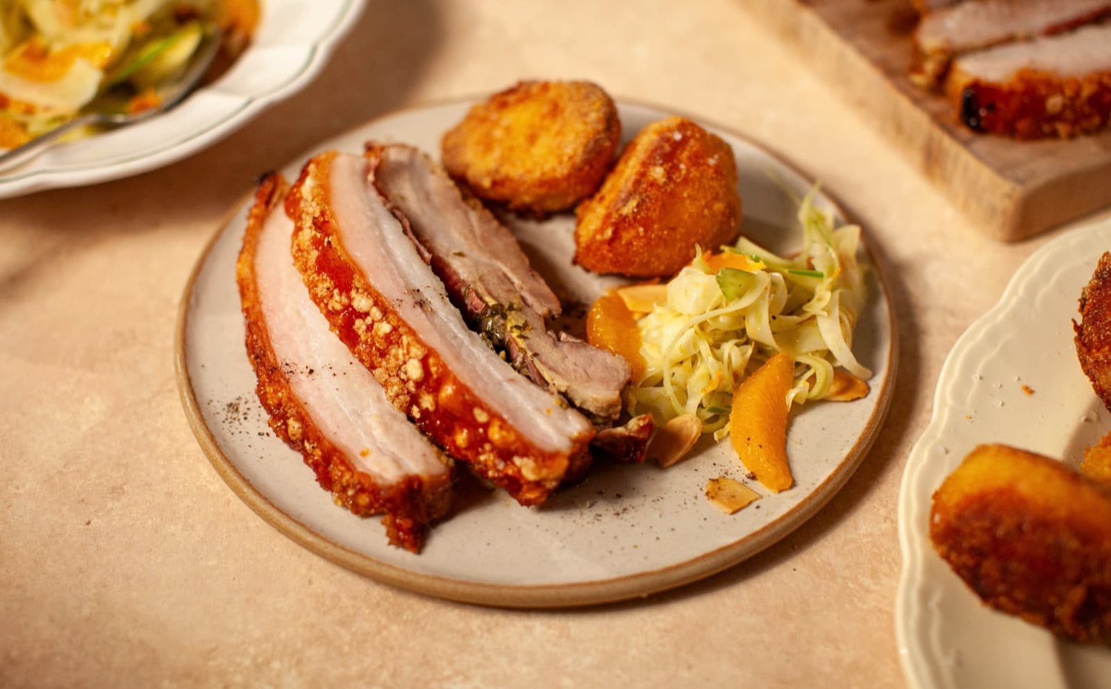 Slow-roast pork belly with crispy roasted potatoes and a fennel and orange salad