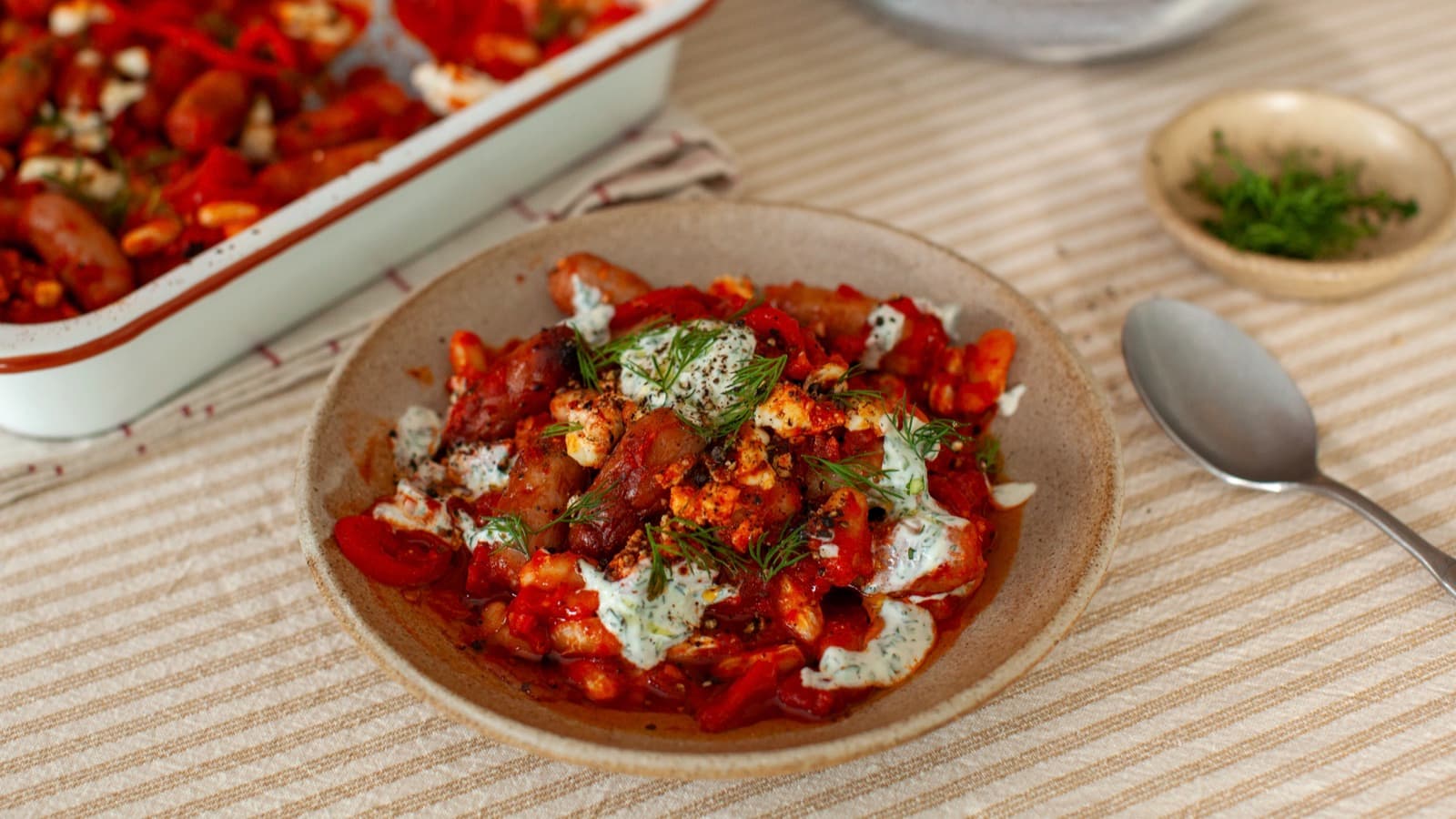 Harissa Cocktail Sausage Traybake with herby tahini yoghurt